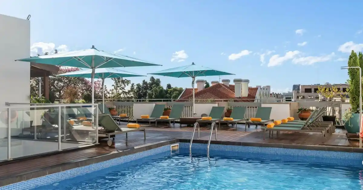 Hotel Madeira, Funchal, portugal rooftop swimming pool with sunloungers around the pool on a bright summers day.