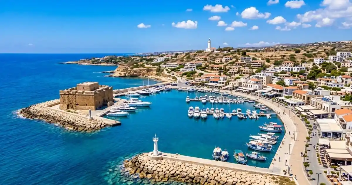 Paphos Medieval Castle, Promenade and fishing boats in the harbour on a sunny Mediterranean day.